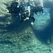 Load image into Gallery viewer, Three divers in front of Ben's Arch, a scenic reef dive in Cirkewwa, Malta
