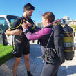Load image into Gallery viewer, Divers doing the buddy check before a sea dive at Qawra Point in Malta
