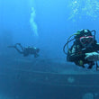 Load image into Gallery viewer, Two scuba divers hovering in front of the Tugboat Rozi in Cirkewwa, Malta
