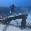Load image into Gallery viewer, A diver hovers over the anchor at popeye village on their PADI Open Water Referral course in Malta
