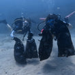 Load image into Gallery viewer, Two divers holding four mesh bags full of trash during a Dive Against Debris in Bugibba, Malta
