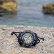 Load image into Gallery viewer, A compass on rocks by the shore in Saint Paul's Bay, used on the PADI navigation dive for the advanced open water course
