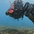 Load image into Gallery viewer, A diver with a mesh bag full of trash collected during a debris dive from a PADI Eco dive centre in Malta
