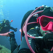 Load image into Gallery viewer, Diver with pink mask and snorkel taking a selfie underwater
