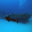 Load image into Gallery viewer, A diver poses on a scuba dive in front of the P29 wreck in Cirkewwa, Malta

