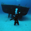 Load image into Gallery viewer, A diver kneeling on the sand at 30m on a fun dive in front of the P29 wreck at Cirkewwa, Malta

